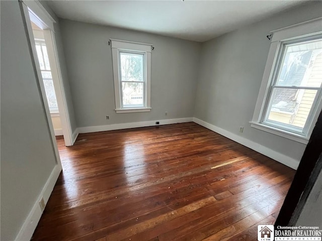 unfurnished room with dark wood-type flooring