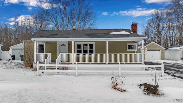 view of front facade featuring a garage, an outdoor structure, and covered porch