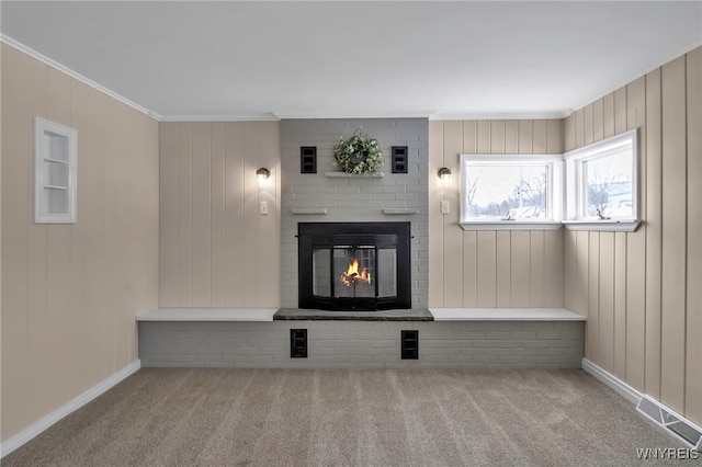 unfurnished living room with ornamental molding, light colored carpet, and a fireplace