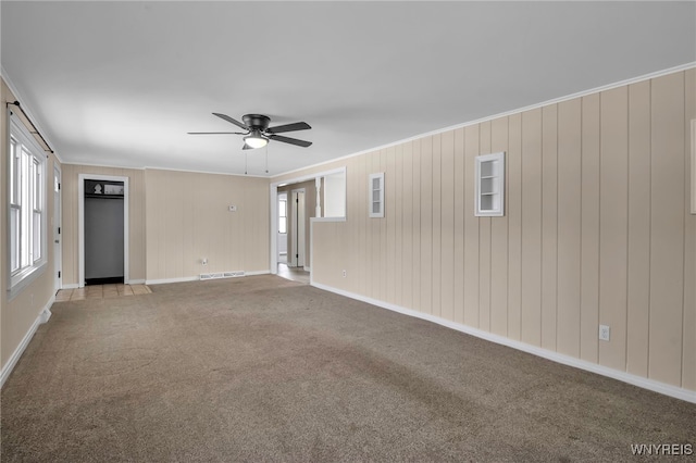 carpeted empty room featuring crown molding and ceiling fan