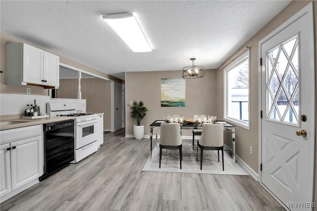 kitchen featuring white cabinetry, decorative light fixtures, light wood-type flooring, white range with gas cooktop, and black dishwasher