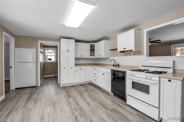 kitchen with white cabinetry, white appliances, sink, and light hardwood / wood-style floors