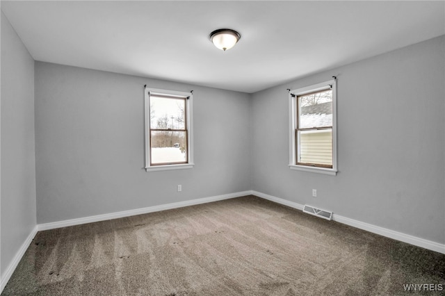 unfurnished room with a wealth of natural light and carpet flooring