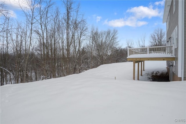 yard layered in snow with a wooden deck