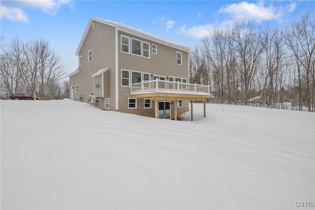 snow covered house with a wooden deck