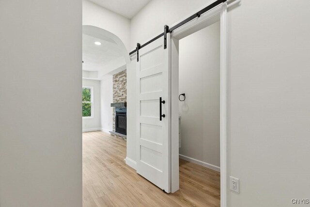 hall featuring a barn door and light wood-type flooring