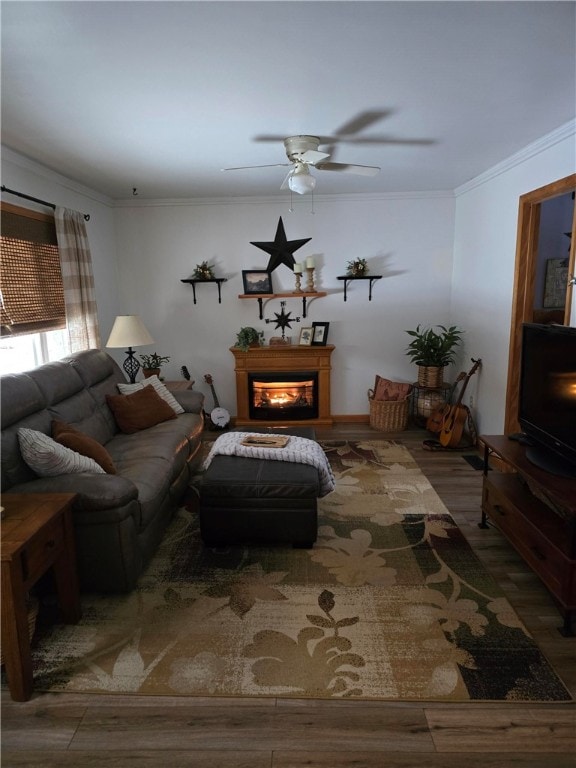 living room featuring hardwood / wood-style flooring, ornamental molding, and ceiling fan