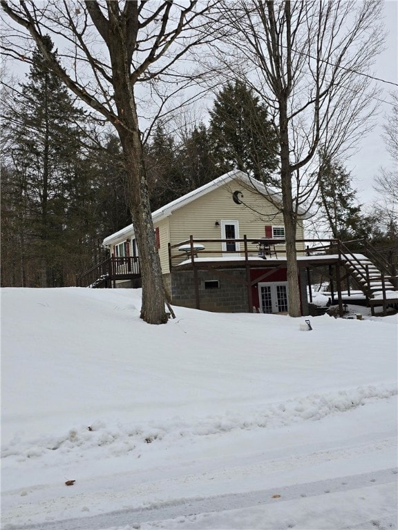 snow covered property with a deck