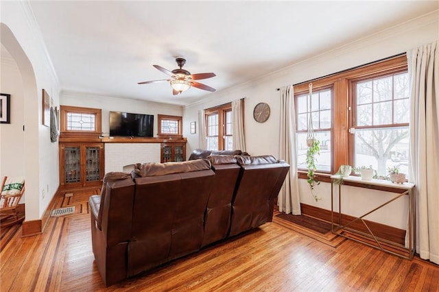 living room featuring crown molding, ceiling fan, and light hardwood / wood-style flooring