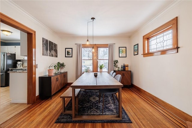 dining space featuring ornamental molding and light wood-type flooring