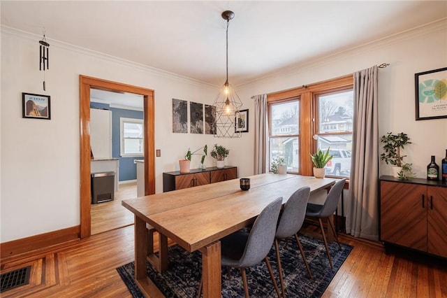 dining area featuring ornamental molding and light wood-type flooring