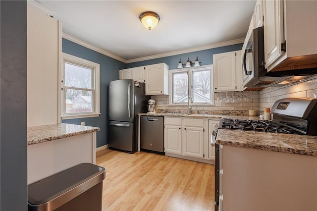 kitchen featuring white cabinetry, sink, stainless steel appliances, and light wood-type flooring