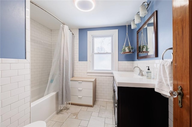 full bathroom featuring toilet, vanity, shower / bathtub combination with curtain, and tile walls