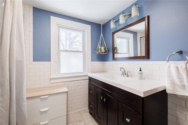 bathroom featuring plenty of natural light, tile patterned flooring, tile walls, and vanity