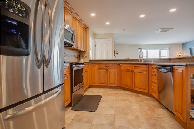 kitchen with sink, decorative backsplash, light tile patterned flooring, and appliances with stainless steel finishes