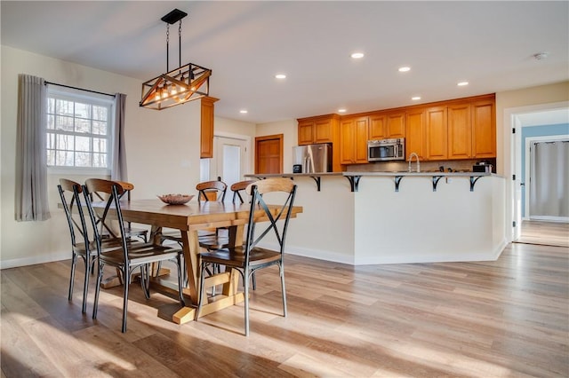 dining space featuring sink and light wood-type flooring