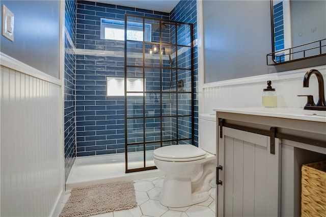 bathroom featuring vanity, tiled shower, tile patterned floors, and toilet