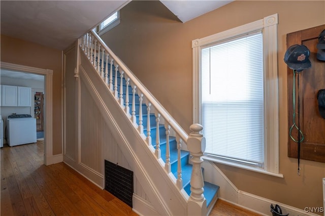 staircase featuring wood-type flooring and washer / dryer