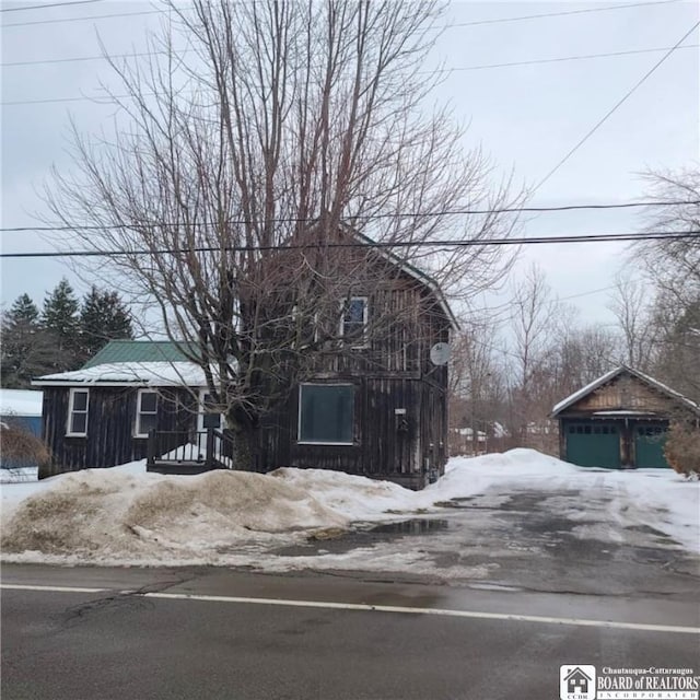 front facade with a garage and an outbuilding