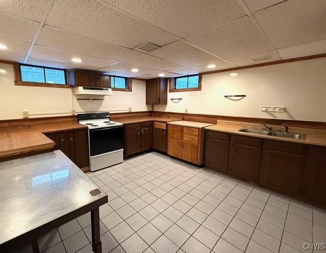 kitchen with electric stove, sink, dark brown cabinets, and a drop ceiling