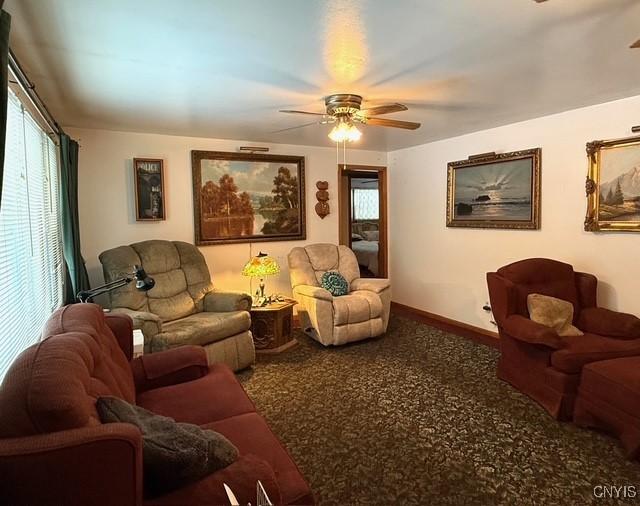 carpeted living room with ceiling fan