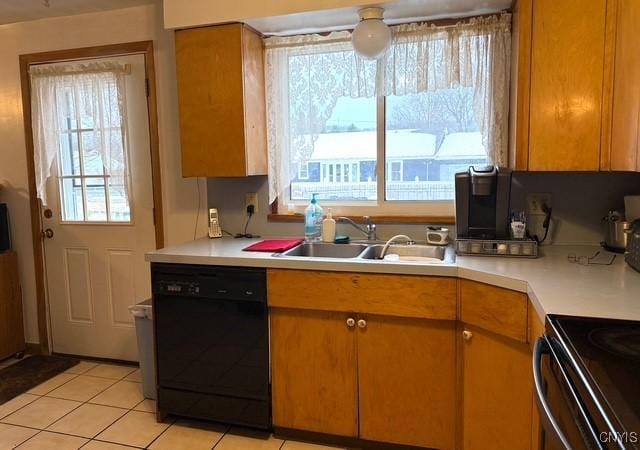 kitchen with black dishwasher, sink, and light tile patterned floors