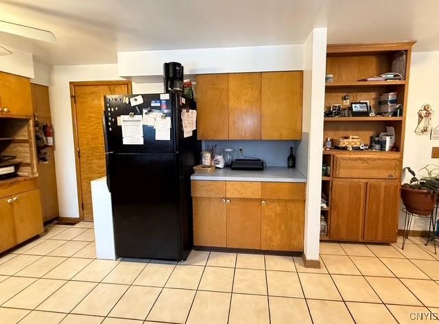 kitchen featuring black refrigerator and light tile patterned flooring