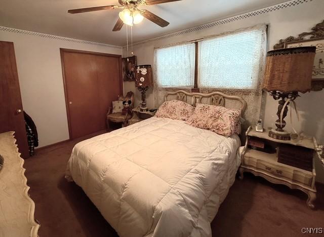 bedroom featuring ceiling fan, a closet, and dark colored carpet