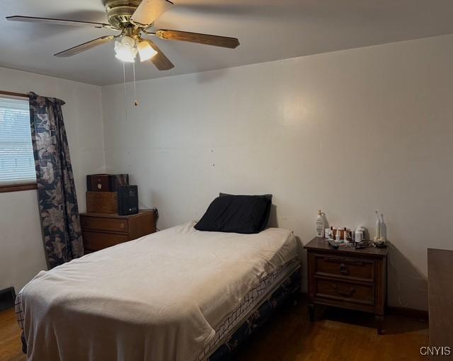 bedroom with ceiling fan and dark hardwood / wood-style flooring