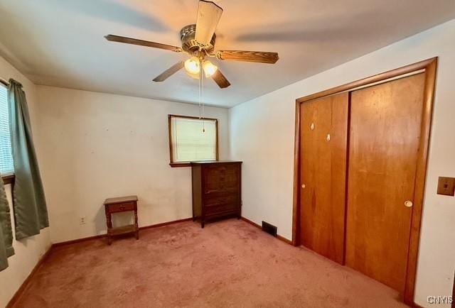 unfurnished bedroom featuring light colored carpet, ceiling fan, and a closet