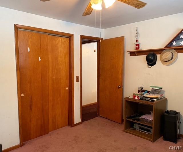 carpeted bedroom with ceiling fan and a closet