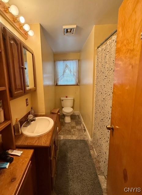 bathroom with vanity, toilet, and curtained shower