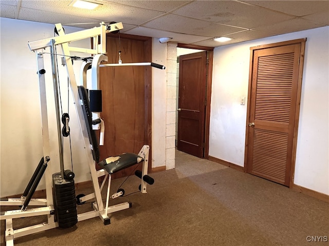 exercise area with carpet floors and a paneled ceiling