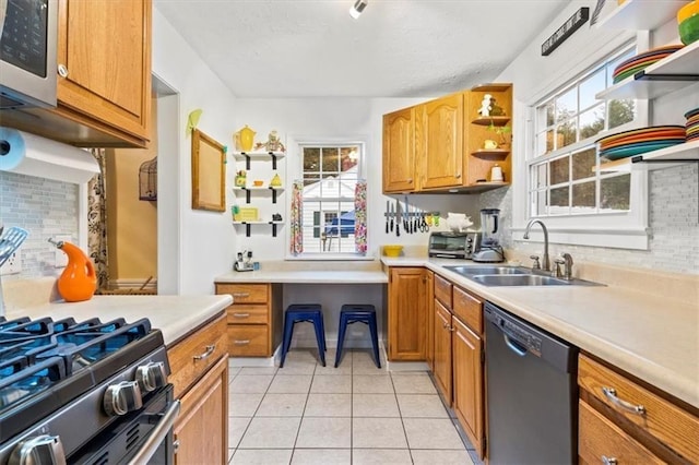 kitchen featuring light tile patterned flooring, dishwasher, sink, and backsplash