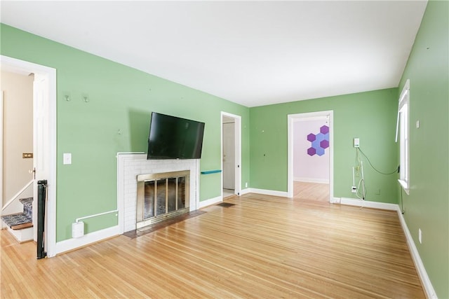 unfurnished living room with a fireplace and wood-type flooring