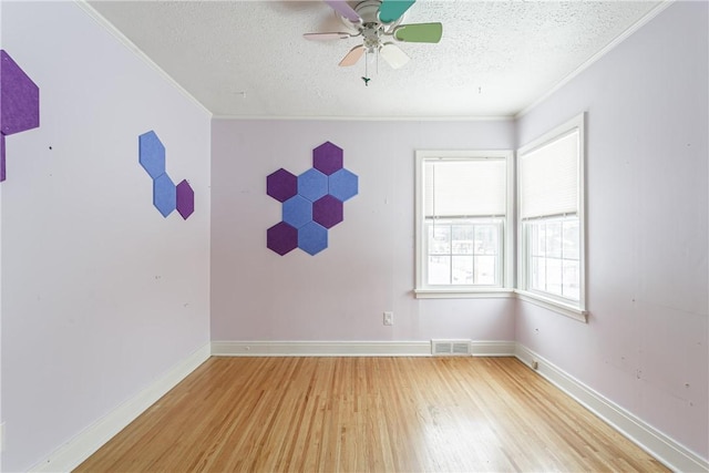 unfurnished room featuring wood-type flooring, ornamental molding, ceiling fan, and a textured ceiling