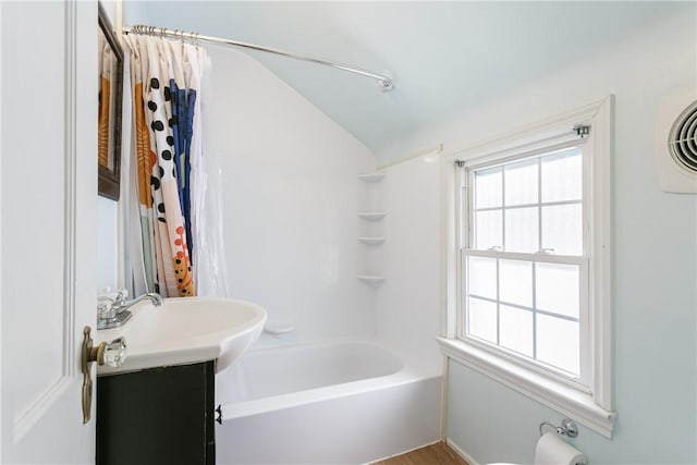 bathroom with vanity, shower / bathtub combination with curtain, and vaulted ceiling