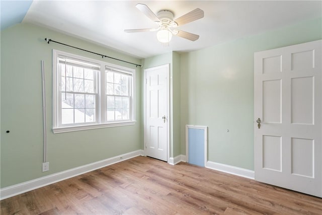 unfurnished bedroom with ceiling fan, lofted ceiling, light wood-type flooring, and a closet