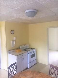 kitchen with white gas range and white cabinets