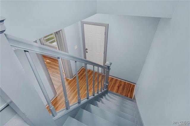 staircase featuring hardwood / wood-style floors and vaulted ceiling