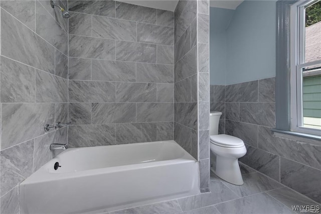 bathroom with shower / washtub combination, a wealth of natural light, tile walls, and toilet