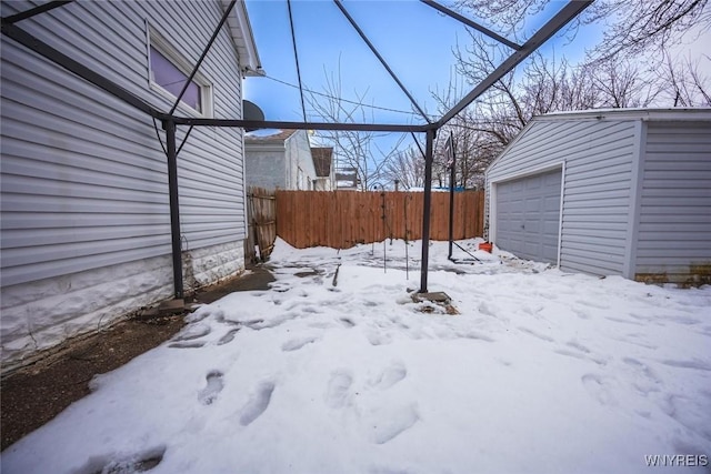 yard covered in snow with a garage and an outbuilding