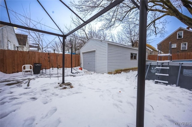 snowy yard with an outbuilding and a garage