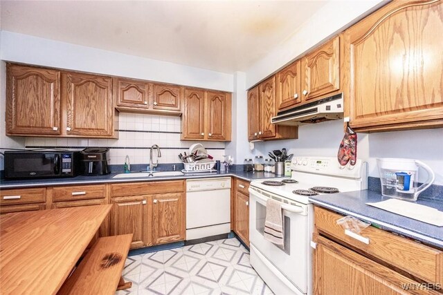 kitchen with tasteful backsplash, sink, and white appliances