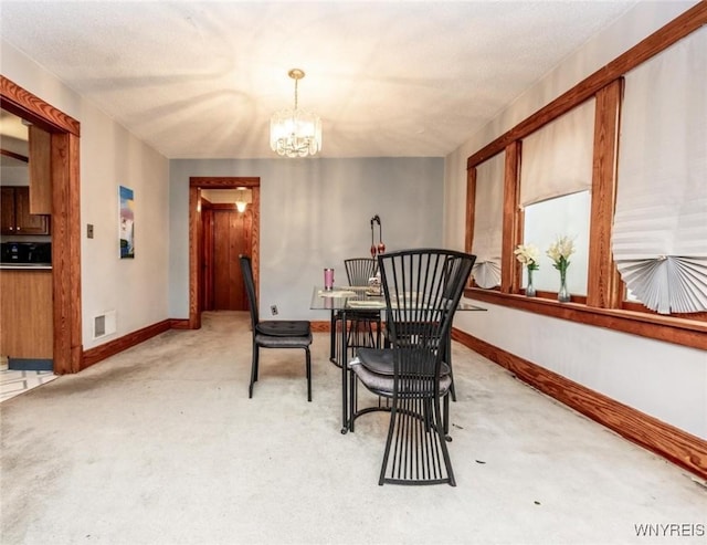 dining area featuring carpet flooring and a chandelier