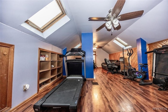 exercise area with hardwood / wood-style flooring, vaulted ceiling with skylight, and ceiling fan