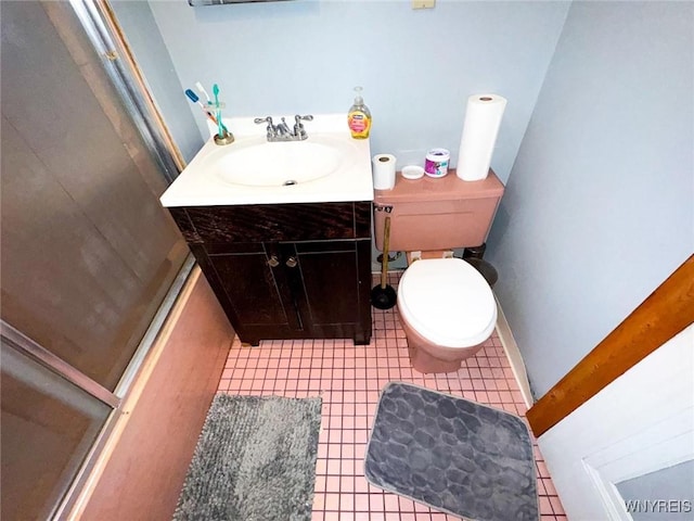 bathroom featuring vanity, tile patterned flooring, toilet, and walk in shower