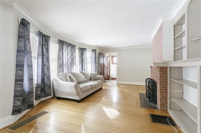 living room featuring crown molding, a fireplace, and light wood-type flooring