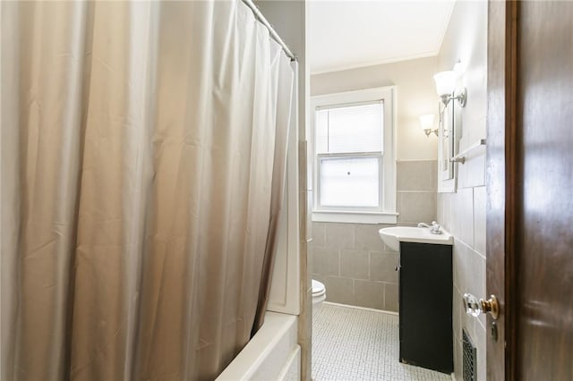 full bathroom with toilet, tile walls, ornamental molding, vanity, and tile patterned flooring