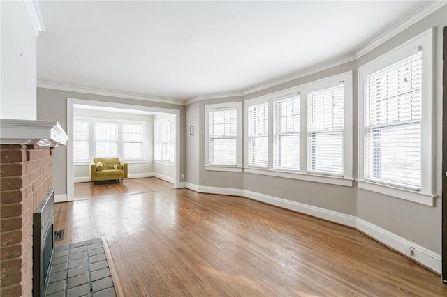 unfurnished living room with crown molding, a brick fireplace, and a healthy amount of sunlight